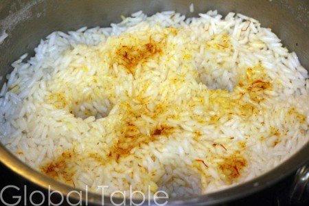 Pour seasonings over rice, poke holes with the handle of a wooden spoon, cover, and steam.